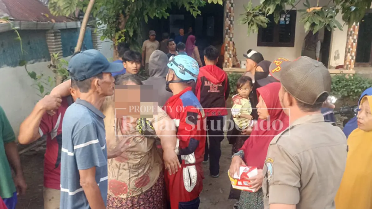 EVAKUASI KORBAN: Petugas pemadam kebakaran (Damkar) membopong Nur, 45, di pekarangan milik Ana, 50, warga Desa Awar-awar, Kecamatan Asembagus, Jumat (29/5). (HUMAIDI/JPRS)