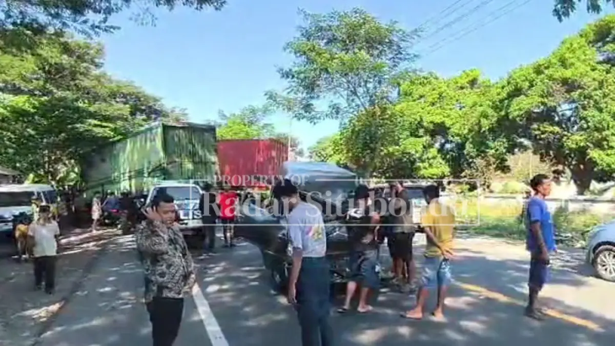 LAKA BERUNTUN: Warga menyaksikan kendaraan truk yang melintang di badan Jalan Raya Desa Curah Kalak, Kecamatan Jangkar, Jumat (5/6). (HUMAIDI/JPRS)
