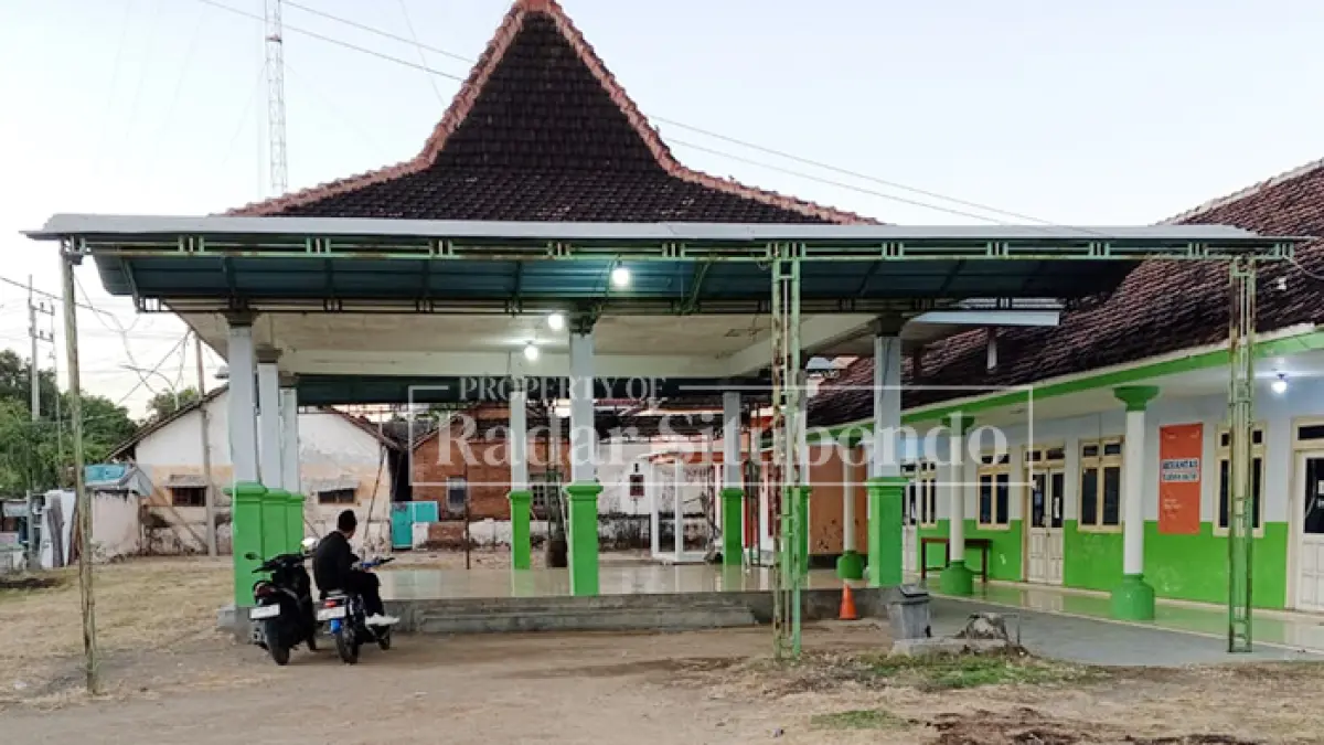 LAPANGAN DESA: Seorang warga berhenti untuk beristirahat di pendapa halaman Kantor Desa Sletreng, Kecamatan Kapongan, Kabupaten Situbondo, Minggu (7/6). (Ahmad Rifa