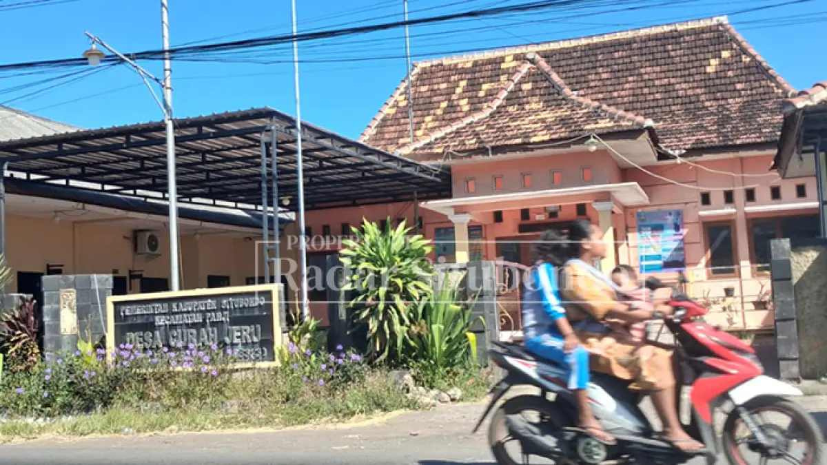 MASUK BALAI DESA: Seorang warga hendak memasuki gerbang menuju halaman Balai Desa Curah Jeru, Kecamatan Panji, Kabupaten Situbondo, Kamis (11/6). (Ahmad Rifa