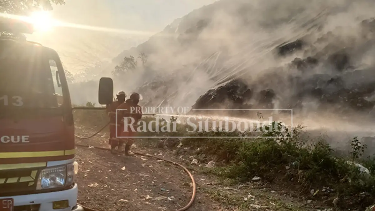 BERASAP: Petugas Pemadam Kebakaran (Damkar) Situbondo memadamkan kobaran api di Tempat Pembuangan Akhir (TPA) Desa Sliwung, Kecamatan Panji, Situbondo, Kamis (11/6) sore. (Ahmad Rifa