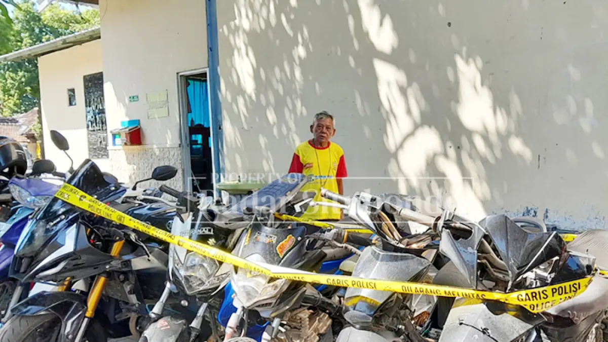 HASIL OPERASI: Penjaga parkir menata motor hasil operasi balap liar di halaman belakang Mapolres Situbondo, Rabu (17/6). (Humaidi/JPRS)