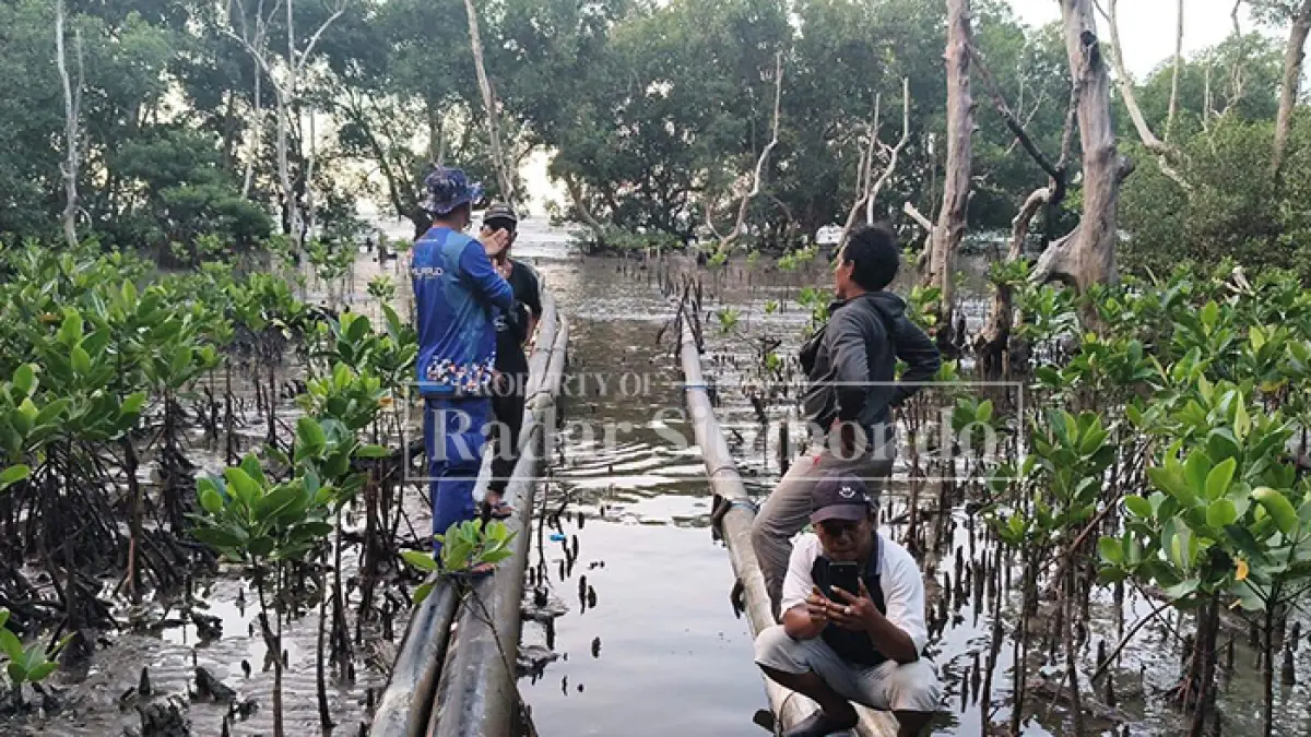 RESPON KELUHAN: Kasatpolairud Polres Situbondo menelusuri aliran pipa milik PT. Fuyuan di bibir pantai Kecamatan Banyuglugur, Minggu (21/6). (HUMAIDI/JPRS)
