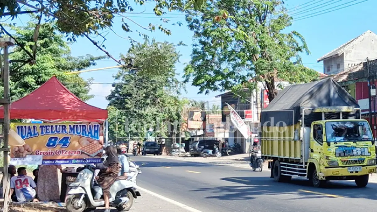 DIOBRAL MURAH: Seorang pedagang memasang tulisan "Harga Telur Murah" di lapaknya di Pasar Panji, Kecamatan Panji, Situbondo, Jumat (26/6). (Ahmad Rifa