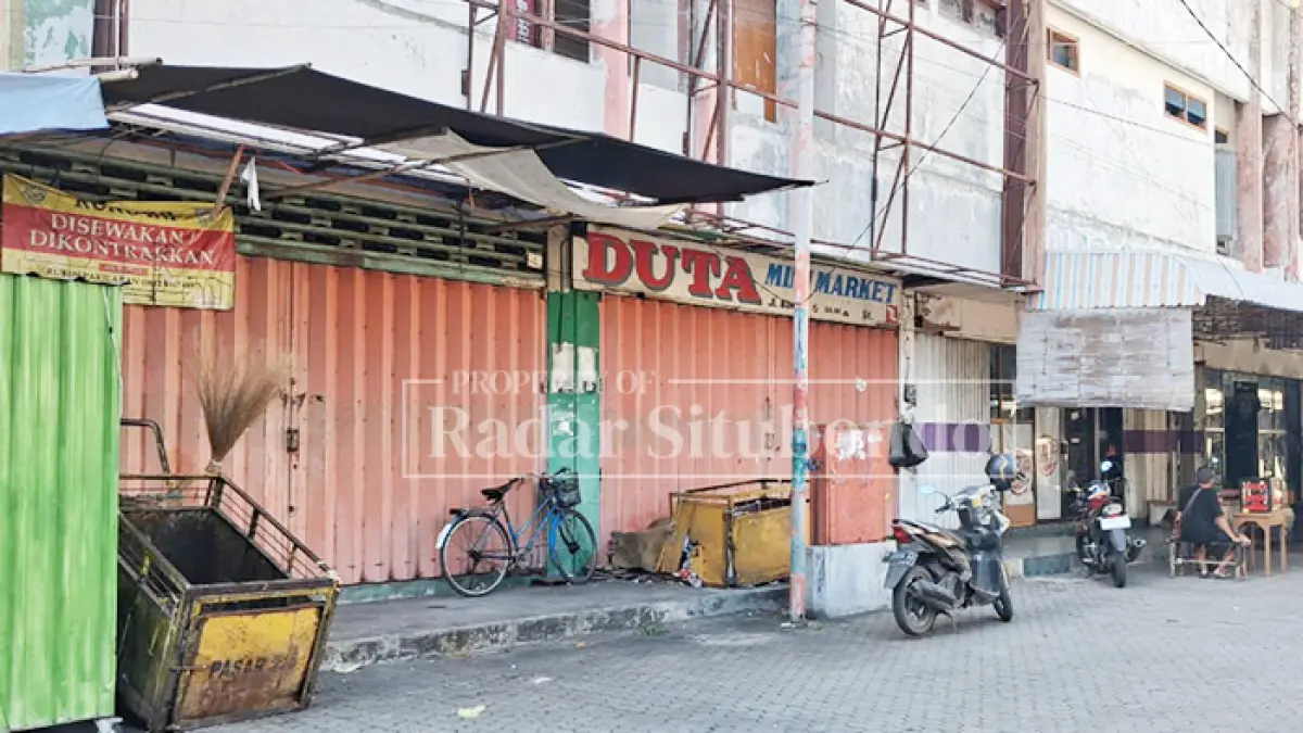 BANYAK YANG TUTUP: Seorang warga menunggu calon penjual emas di depan deretan ruko Pasar Mimbaan Baru, Kecamatan Panji, Kamis (2/7). (Ahmad Rifa