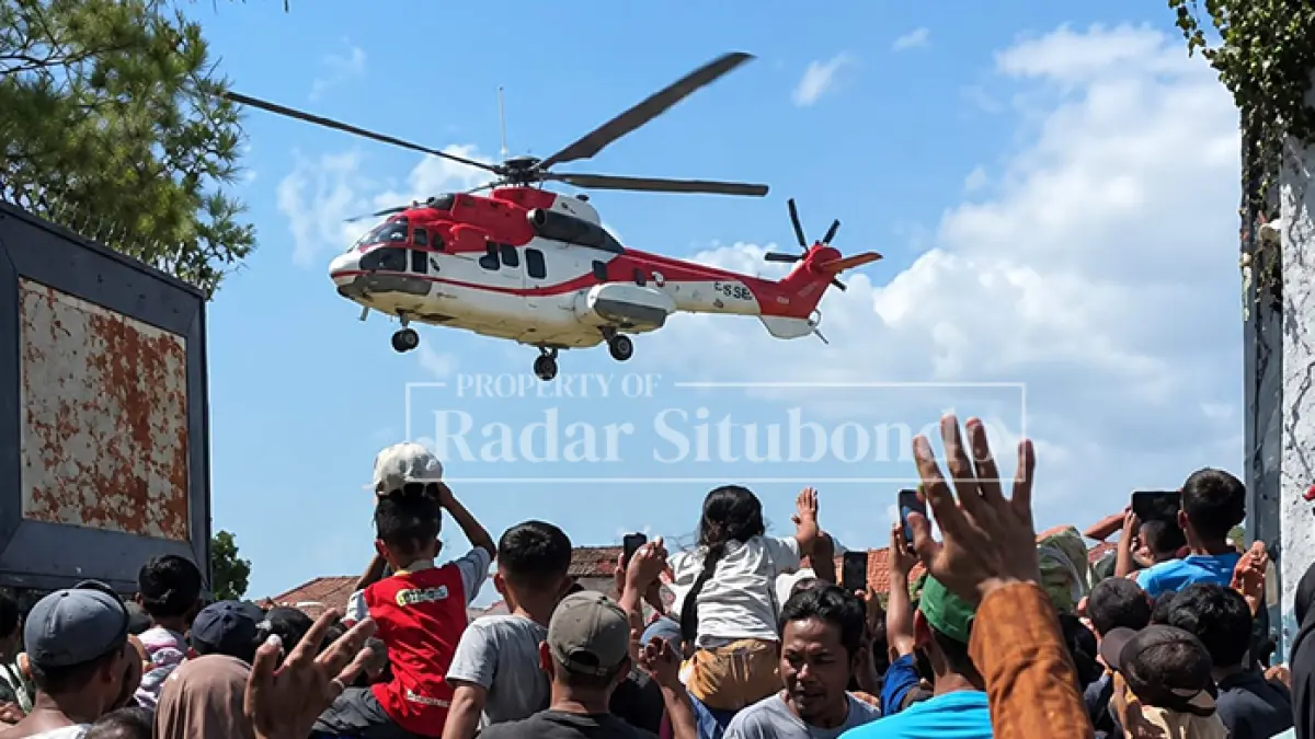 HEBOH: Sejumlah warga Kecamatan Besuki melambaikan tangan ke arah helikopter yang melintas di atas mereka saat menyambut kedatangan Wakil Presiden Republik Indonesia di Situbondo, Jumat (10/7). (Ahmad Rifa