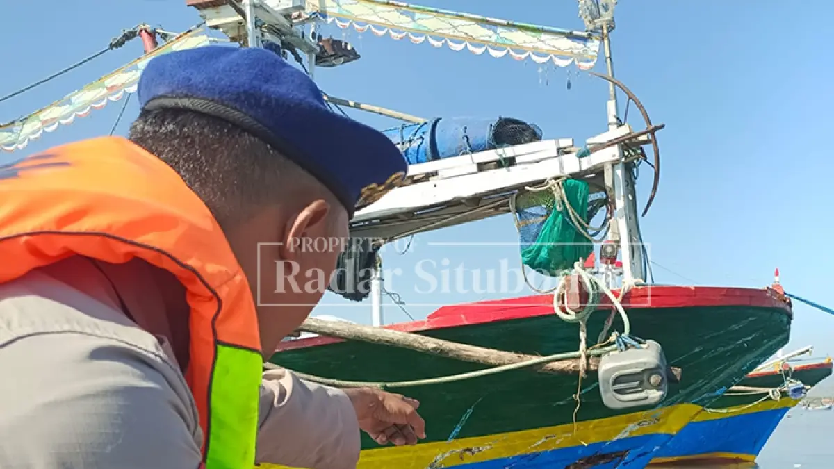 BARANG BUKTI LAKA: Anggota Satpolarud Polres Situbondo, meninjau Kapal Cantrang, di pinggir pantai, kecamatan Panarukan, Senin lalu (13/7). (HUMAIDI/JPRS)
