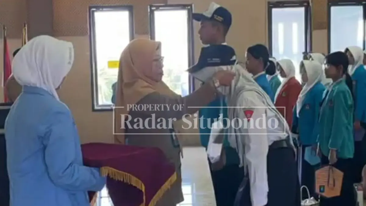 BERI PENYEMATAN: Kepala SMAN 1 Situbondo, Dwi Retno Susanti, M.Pd., menyematkan tanda pengenal kepada peserta didik baru yang mengikuti Masa Pengenalan Lingkungan Sekolah (MPLS) di aula SMAN 1 Situbondo, Selasa (14/7). (Ahmad Rifa