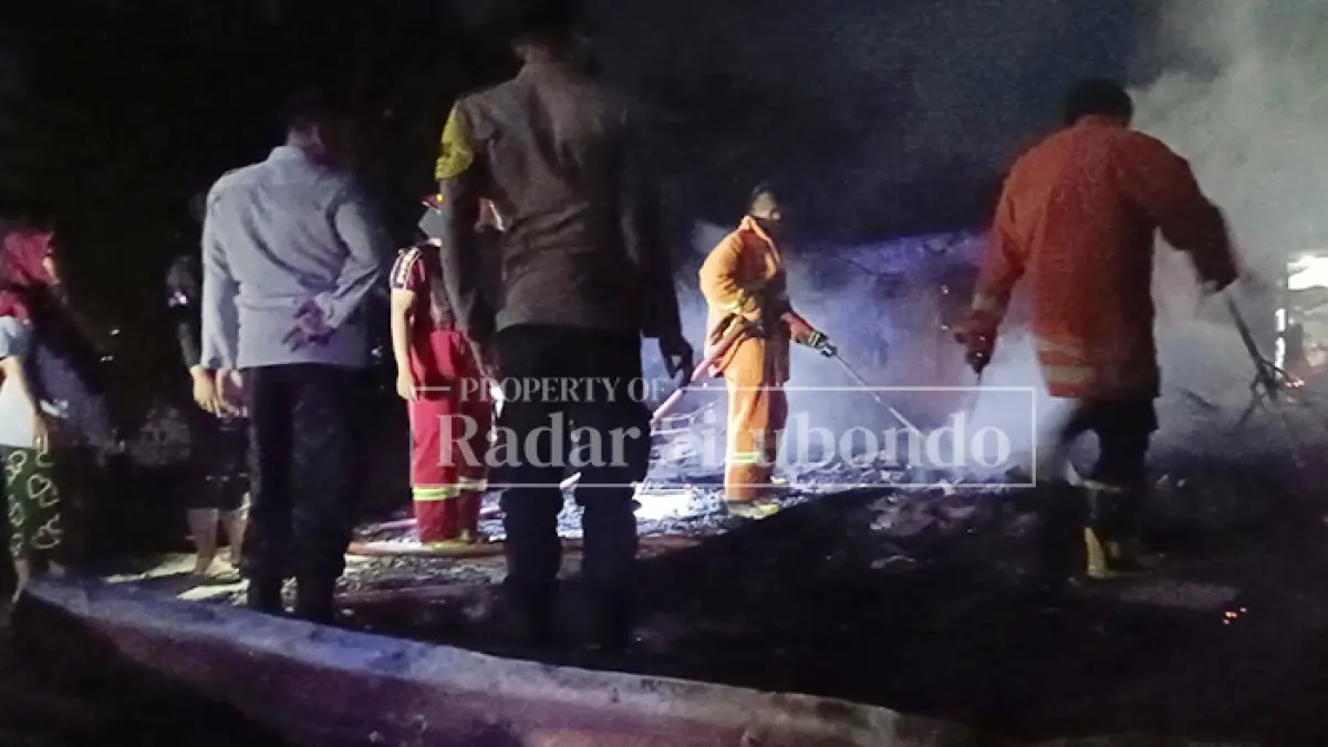 RUGI BESAR: Petugas Pemadam Kebakaran berupaya memadamkan api yang melalap dua rumah milik warga di Desa Asembagus, Kecamatan Asembagus, Situbondo, Kamis (16/7) malam. (Ahmad Rifa