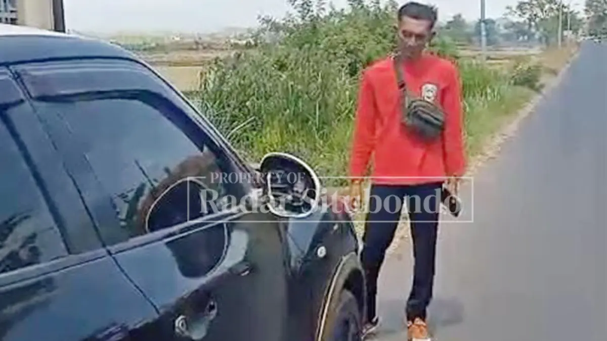 BIKIN GEGER: Kepala Dusun Tenggir, Edi Mulyono melihat mobil bernopol W 1565 CS di pinggir Jalan Desa Tenggir, Kecamatan Panji, Selasa (21/7). (HUMAIDI/JPRS)
