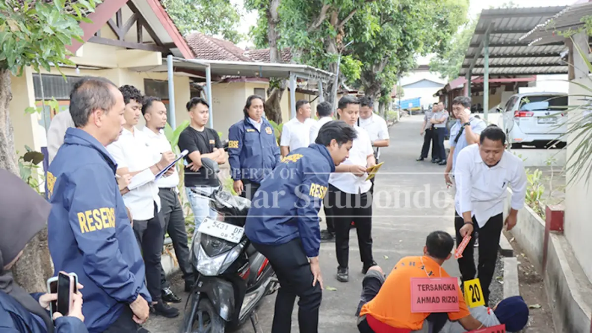 REKA ULANG: Tersangka Ahmad Rizki Hidayatur Rahman, 32, memeragakan pembunuhan terhadap istrinya yang seorang bidan, Murtafia Rafika Devi, 34, di halaman belakang Mapolres Situbondo, Selasa (21/7). (HUMAIDI/JPRS)
