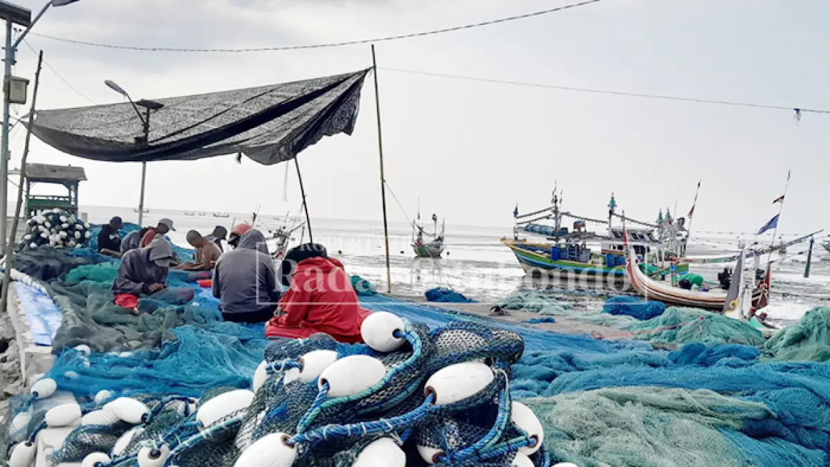 KERJASAMA: Puluhan nelayan sibuk memperbaiki jaring ikan di pelabuhan lama Desa Kilensari, Kecamatan Panarukan, Rabu (29/7). (HUMAIDI/JPRS)
