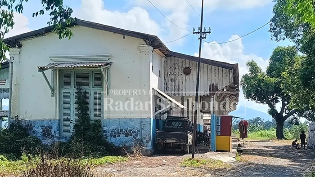 TAK BEROPERASI: Seorang warga beraktivitas di depan bangunan Stasiun Kereta Api Sumberkolak, Kecamatan Panarukan yang menghubungkan Situbondo–Bondowoso–Jember, Kamis (30/7). (Ahmad Rifa