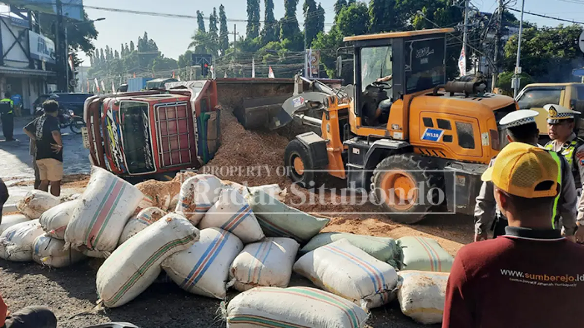 LAKA TUNGGAL: Anggota Satlantas Polres Situbondo, dibantu warga mengevakuasi serbuk kayu di simpang empat Alun-Alun Kota Situbondo, (5/8). (HUMAIDI/JPRS)
