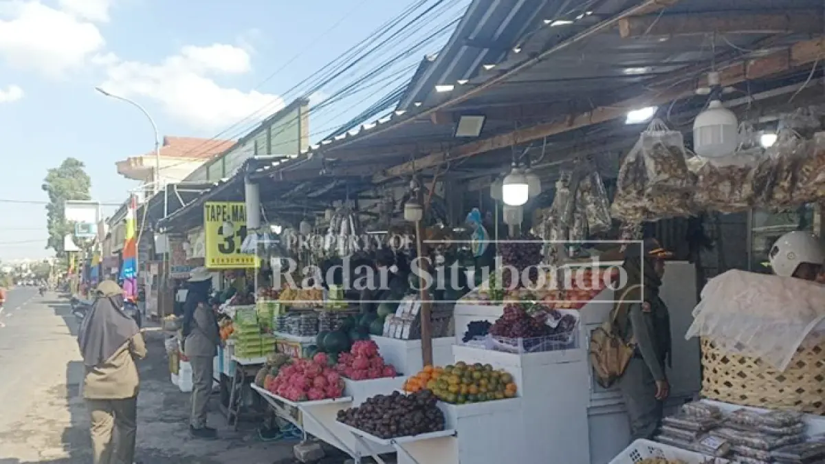 MERUSAK PEMANDANGAN: Anggota Satpol PP berkomunikasi dengan para pedagang buah di pinggir Jalan Raya, Kecamatan Asembagus, Kamis (6/8). (HUMAIDI/JPRS)
