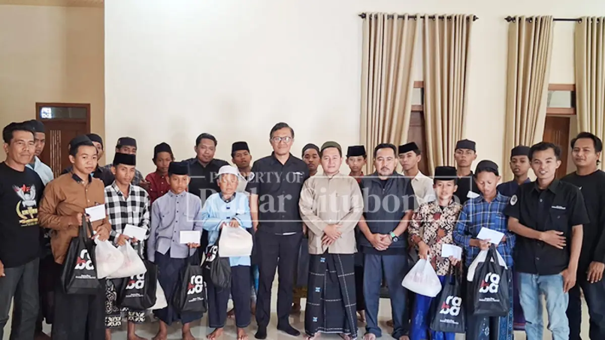 BERBAGI: Kabiro Jawa Pos Radar Situbondo, Edy Supriyono (enam dari kiri) bersama Ustad Afif, pengampu Yayasan Panti Asuhan, Qur’ani Al Maimunah, Desa Tenggir, Kecamatan Panji, (berkopyah) foto bareng bersama anak panti asuhan, Jumat (7/8). (HUMAIDI/JPRS)
