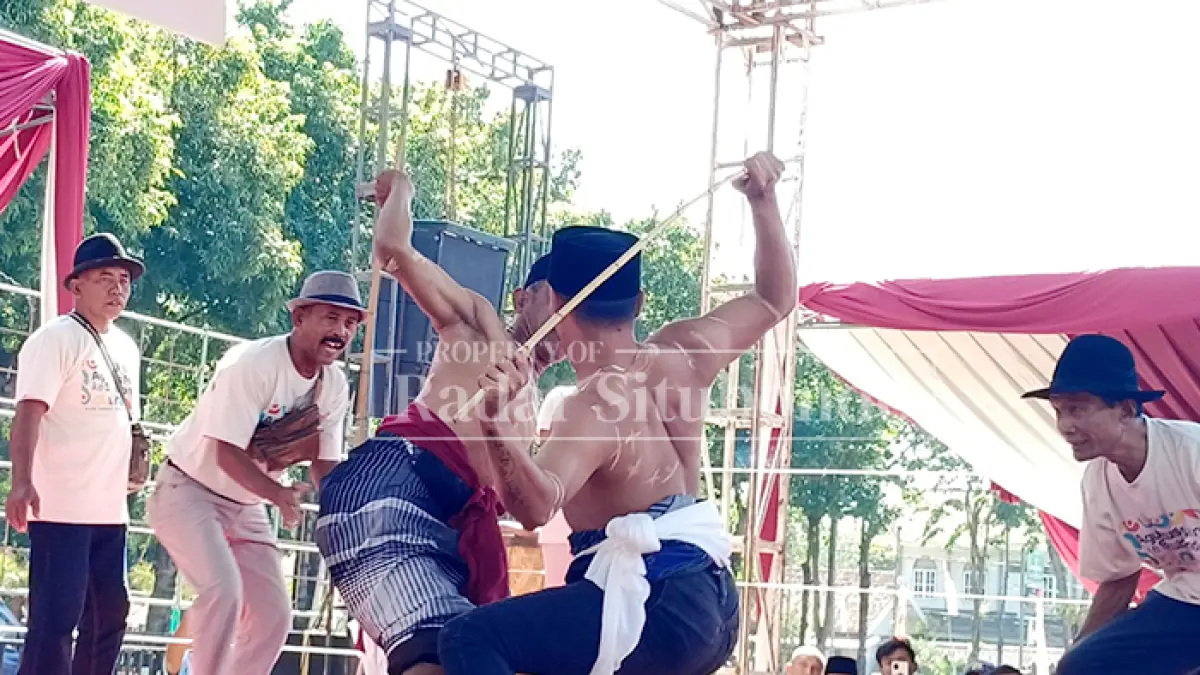 SIAP SIAGA: Dua peserta lomba ojung berlaga di atas arena di Alun-Alun Situbondo, Minggu (9/10). (Ahmad Rifa
