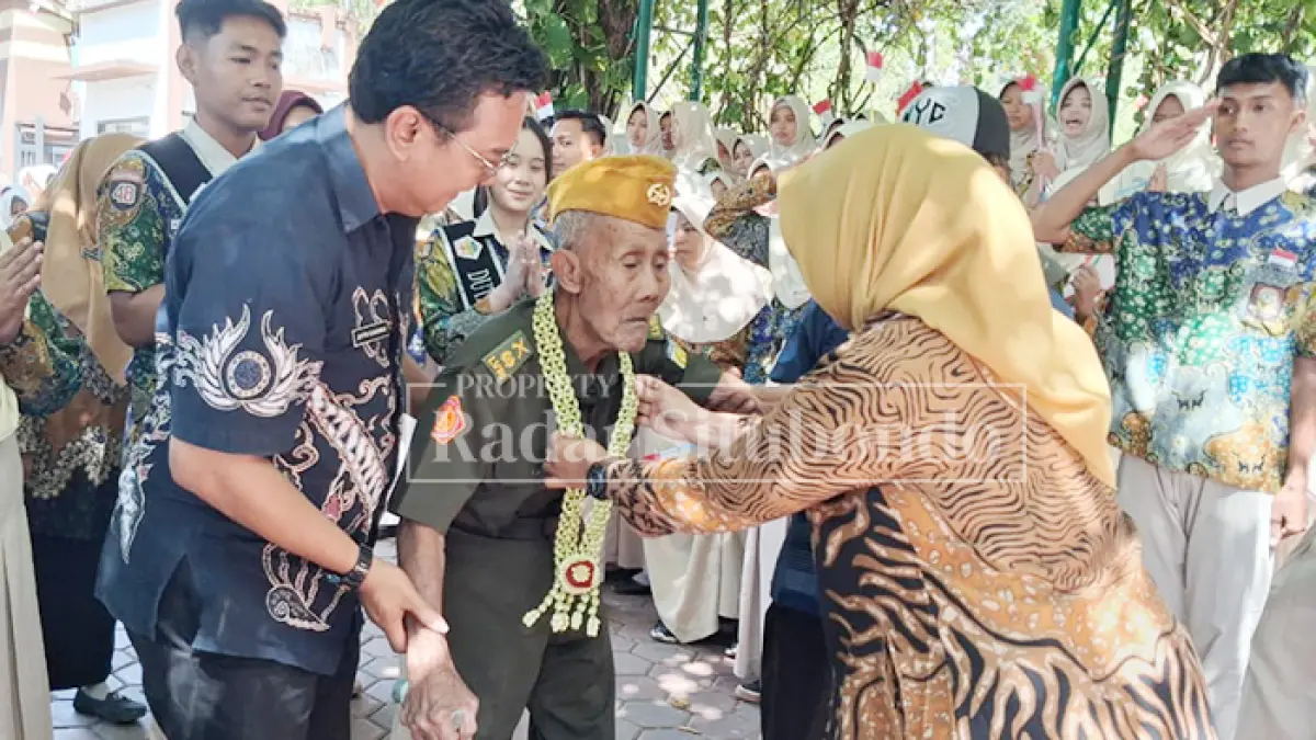 DISAMBUT HARU: Kepala SMADA Prima Nikmatil Hasanah, M.Pd. (kanan) menjemput dan menghadirkan Mat Asin ke sekolah yang dipimpinnya, Kamis (13/8). Mat Asin adalah salah satu pejuang kemerdekaan di Situbondo yang sudah berukur 108 tahun. (Ahmad Rifa