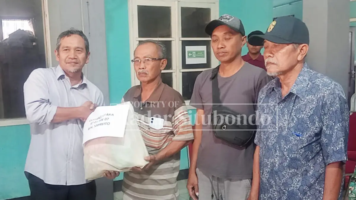 PEDULI SOSIAL: GM PG Asembagus Ir. H. Mulyono (kiri) membagikan sembako kepada warga di Balai Desa Gudang, Kecamatan Asembagus, Jumat (14/8). (HUMAIDI/JPRS)