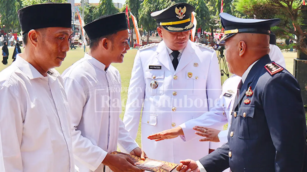 MOMEN BAHAGIA: Dua WBP Rutan Kelas IIB Situbondo menerima surat bebas dari Karutan Kelas IIB Situbondo Suwono, di Alun-Alun Besuki, disaksikan Bupati Situbondo Yusuf Rio Wahyu Prayogo, Senin (17/8). (HUMAIDI/JPRS)
