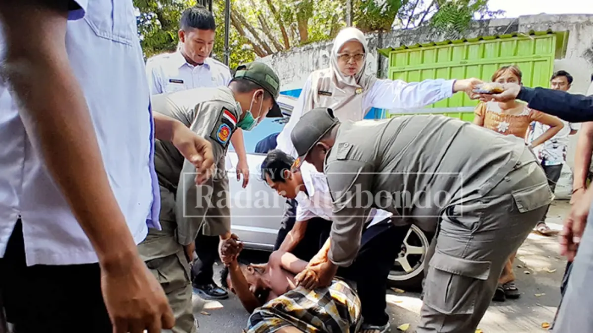 BIKIN HEBOH:Anggota Satpol PP mengevakuasi ODGJ di Jalan Raya, depan DPRD Situbondo, Rabu (19/8). (HUMAIDI/JPRS)

