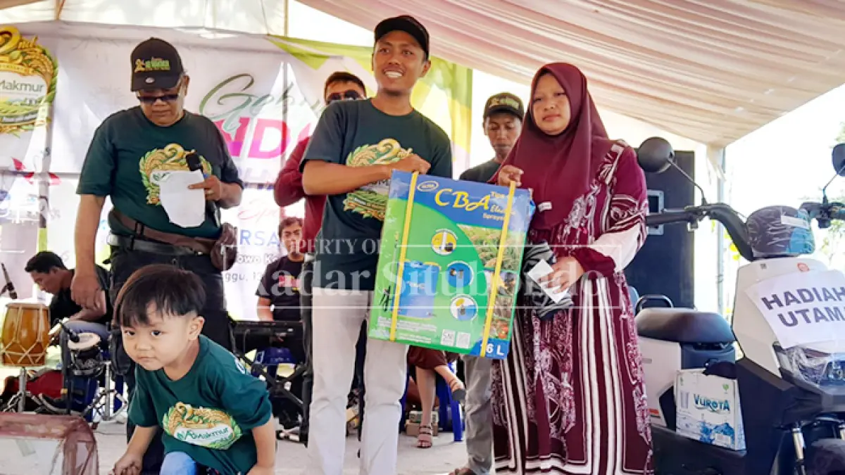 ABADIKAN MOMEN: Owner AB Makmur membagikan hadiah kepada pemenang undian di Desa Kedungdowo, Kecamatan Arjasa, Minggu (13/9). (HUMAIDI/JPRS)