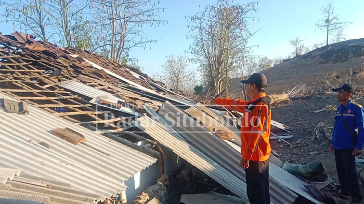 BENCANA ALAM: Anggota BPBD Situbondo menunjuk reruntuhan genteng di rumah milik Biyani, 69, warga Desa Kedunglo, Kecamatan Asembagus, Minggu (13/9). (HUMAIDI/JPRS)