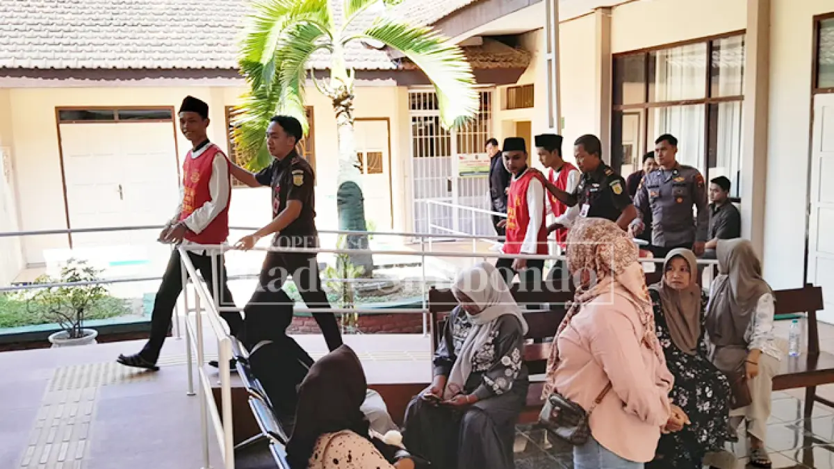 PAKAI BAJU TAHANAN: Tiga terdakwa dikeler memasuki ruang sidang di Pengadilan Negeri (PN) Situbondo, Selasa (15/9). (HUMAIDI/JPRS)