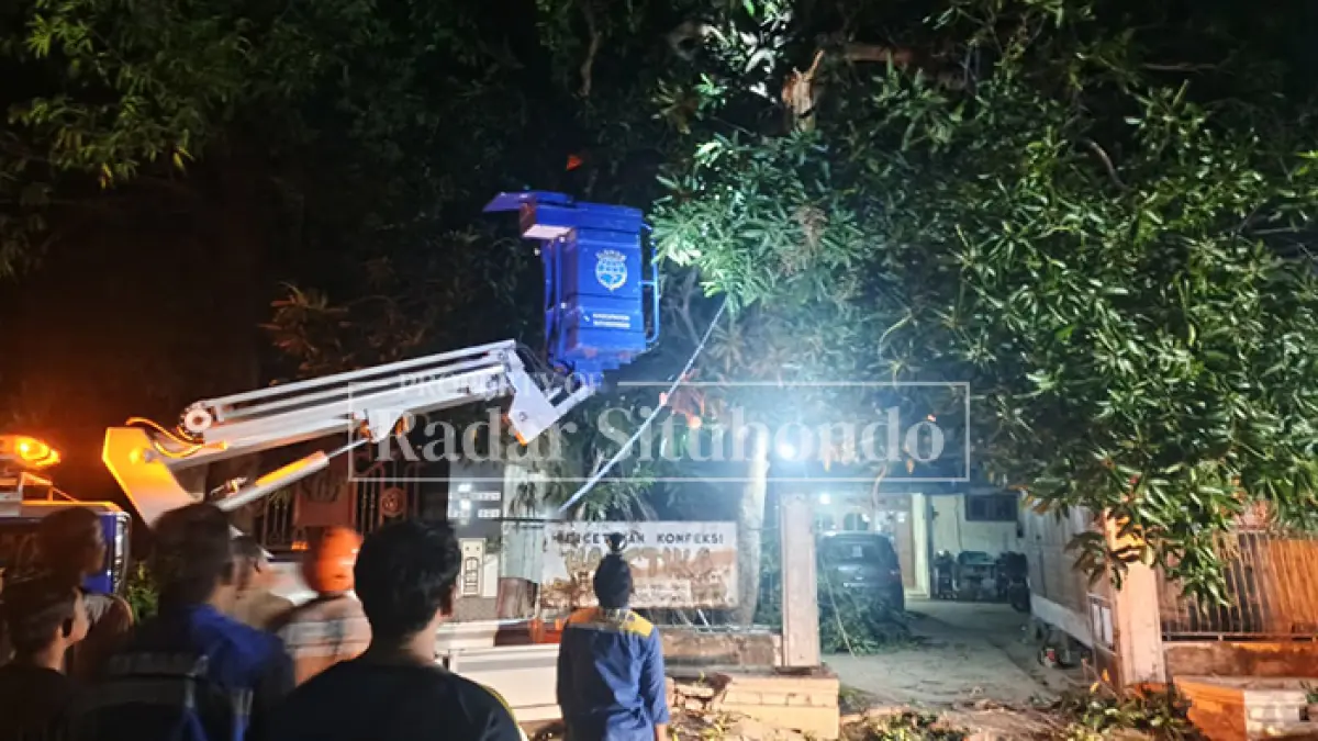 MENUTUP JALAN: Sejumlah petugas membersihkan ranting pohon yang tumbang menutupi jalan di Jalan PB Sudirman, Karangasem, Sabtu (19/9) malam. (Ahmad Rifa