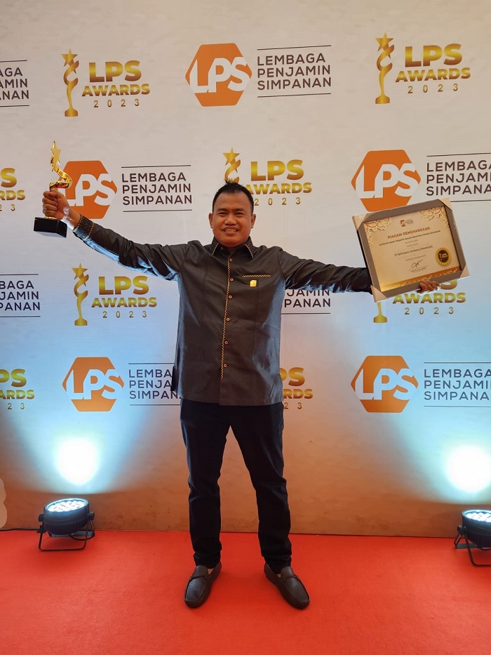 BERSINAR: Direktur Utama Bank Jombang, Afandi Haris Setyo Nugroho, menunjukkan trofi dan piagam penghargaan LPS Awards 2023 kategori Bank Teraktif Dalam Kegiatan Literasi Keuangan, Rabu (6/12).