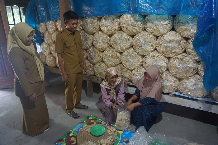 PRODUK UNGGULAN: Kades Made Winarsih (kiri) bersama perangkat desa mengunjungi warga yang tengah mengemas keripik gadung siap goreng.
