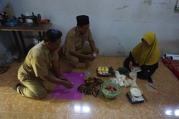 BIKIN KUE: Kades Ceweng Imam Subata (tengah) bersama perangkat desa meninjau salah satu warga yang tengah memproduksi kue, Senin (18/12).