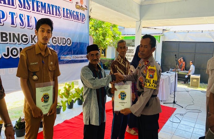Kades Blimbing Wahyu Hidayat (Kiri) menyaksikan penyerahan sertifikat PTSL kepada warganya, Selasa (19/12).