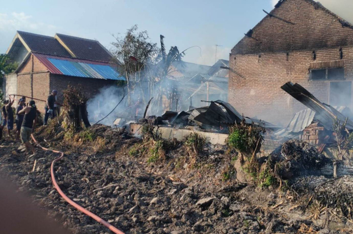 LUDES: Petugas melakukan pembasahan rumah milik Slamet Riwayanto warga Dusun Butuh, Kecamatan Diwek,Jombang yang terbakar, Kamis (21/12) sore.