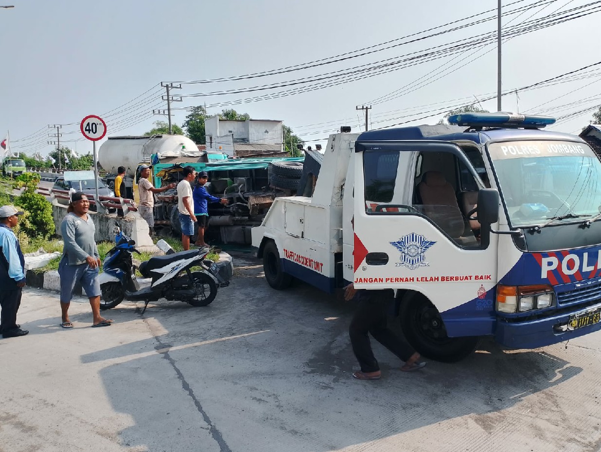 DIEVAKUASI: Dump truck yang mengangkut pasir terguling di jembatan baru Ploso, Desa Bedahlawak, Kecamatan Tembelang, Sabtu (23/12).