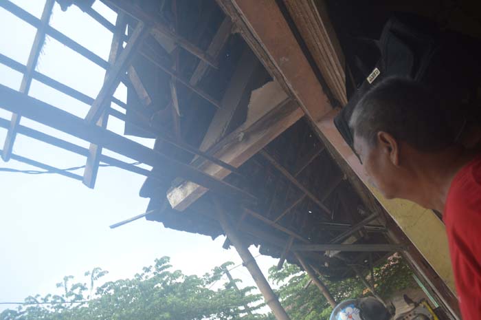 AMBRUK: Suradi menunjukkan atap depan kios di Pasar Mojotrisno, Kecamatan Mojoagung, Rabu (27/12).