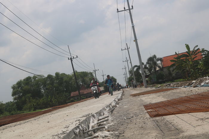 BELUM SELESAI: Proyek jalan cor Ploso-Sumbergondang di Desa Jatibanjar, Kecamatan Ploso baru separo dikerjakan, Sabtu (6/1)