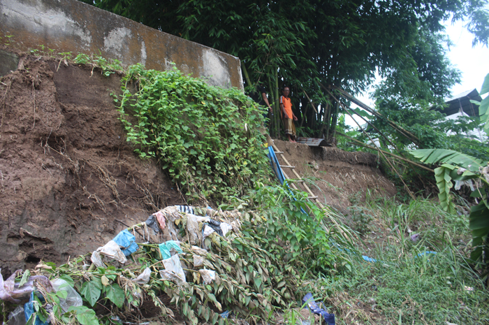 BAHAYA: Salah seorang warga Dusun Betek Barat, Desa Betek, Kecamatan Mojoagung berada di lokasi parapet Kali Gunting yang ambrol, Sabtu (6/1).