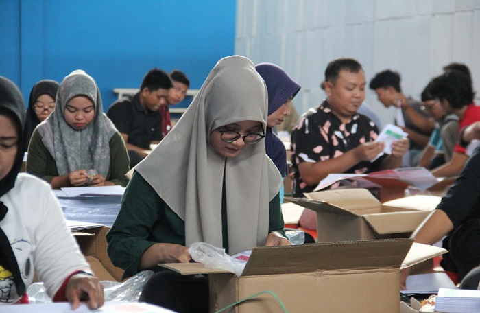 DIKEBUT: Petugas sortir dan lipat surat suara melakukan sortir surat suara di Tenis Indoor Jombang, kemarin.