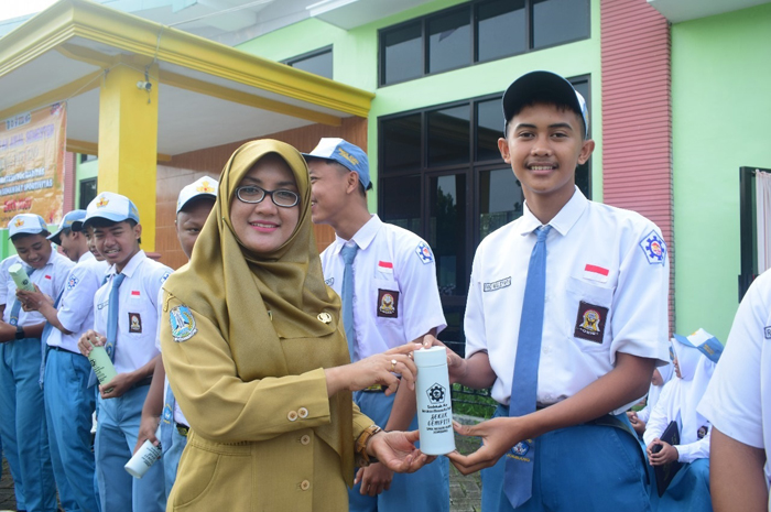 GRATIS: Kepala SMKN Kudu Jombang Amiroh SKom MKom membagikan tumbler gratis ke siswa.