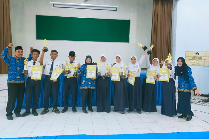 MEMBANGGAKAN: Kepala SMPN 1 Jogoroto, Sunarti (tengah) bersama siswa juara Popkab cabor atletik.