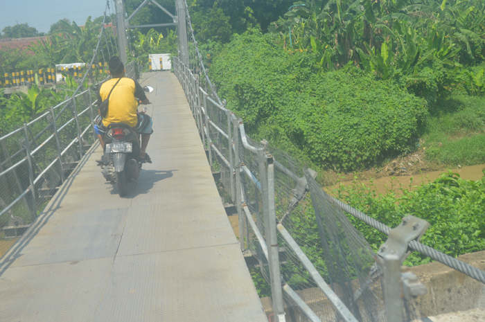 RUSAK: Rangka pagar pengaman jembatan gantung Kali Gunting di Desa Karobelah, Kecamatan Mojoagung tak lagi saling menempel.