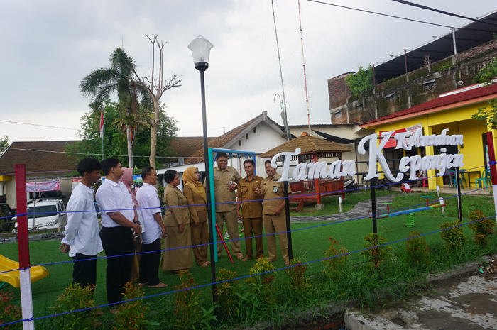 SUDAH BERFUNGSI: Lurah Kepanjen Suwoko (paling kanan) bersama jajaran pegawai kelurahan meninjau taman bermain anak yang baru selesai dibangun.
