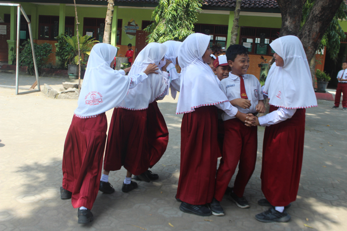 HANYA SERAGAM NASIONAL: Siswa SDN Blimbing Kecamatan Gudo saat bermain di halaman sekolah menggunakan seragam nasional merah putih.