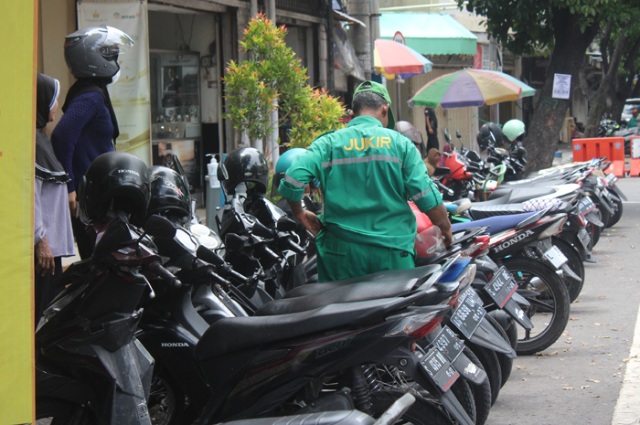 IKUT PEMKAB: Salah seorang jukir di lokasi parkir berlangganan Jl A Yani Jombang memarkir kendaraan, Kamis (18/1).