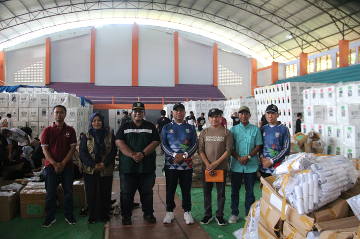 PANTAU: Pj Bupati Jombang Sugiat didampingi komisioner KPU Jombang saat memantau packing logistik di GOR Merdeka, Jumat (26/1).