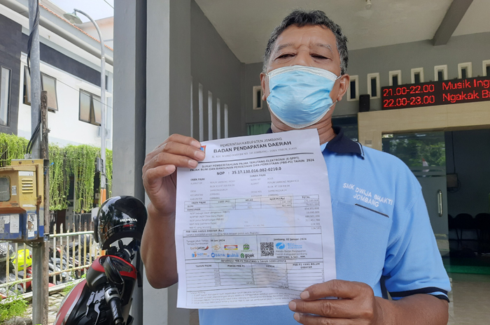 DIKELUHKAN: Agus Supriadi warga Jl Airlangga Kelurahan Jelakombo saat menunjukkan tagihan SPPT-nya.