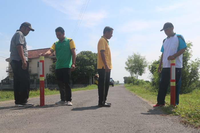 DIASPAL: Kepala Desa Rejosopinggir Yoyok Supriyanto (baju kuning) bersama perangkat desa saat mengecek hasil pembangunan jalan lingkungan yang selesai diaspal.