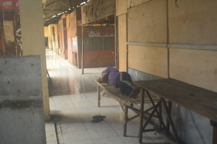 SEPI: Salah seorang pedagang tengah beristirahat di antara deretan kios lantai dua PCN Jombang yang tutup, Kamis (1/2).