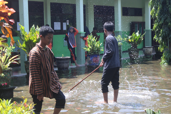 BANJIR: Air menggenang hingga setinggi mata kaki di halaman SMPN 2 Gudo, Jumat (2/2).